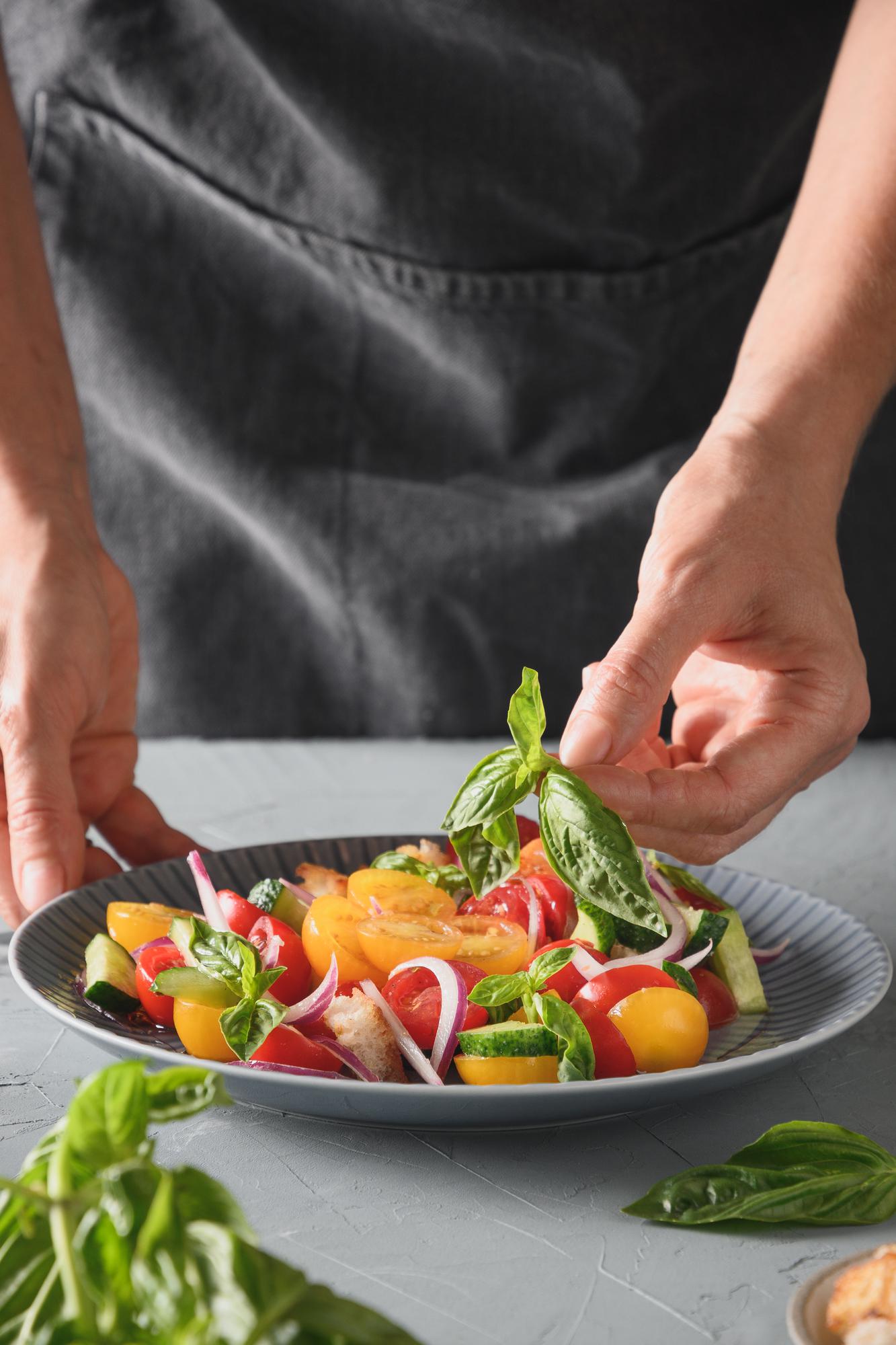 Chef preparing a simple plated dish with seasonal vegetables